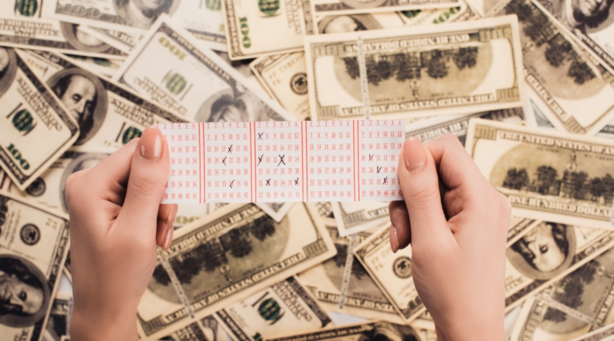 Person Holding Lottery Ticket With Dollars in Background